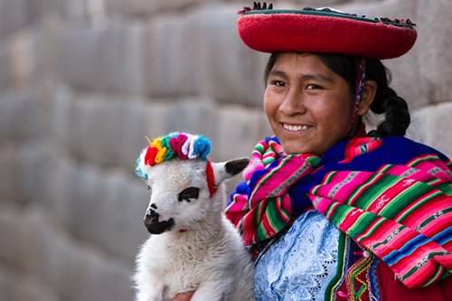 Peruvian girl with baby lamb in Cusco